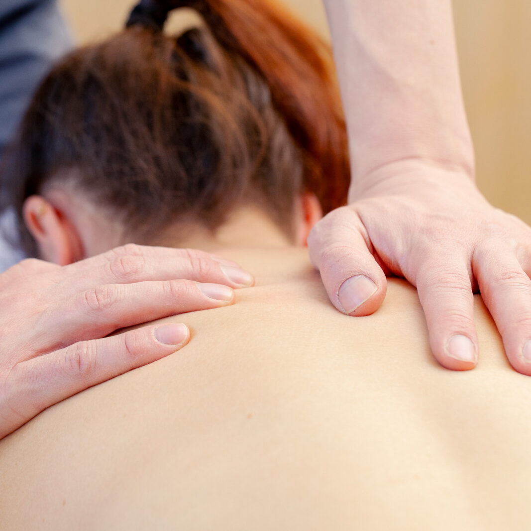 Während der physiotherapeutischen Massage wird sanft Druck auf den Rücken ausgeführt | Physiotherapie Schmeddes